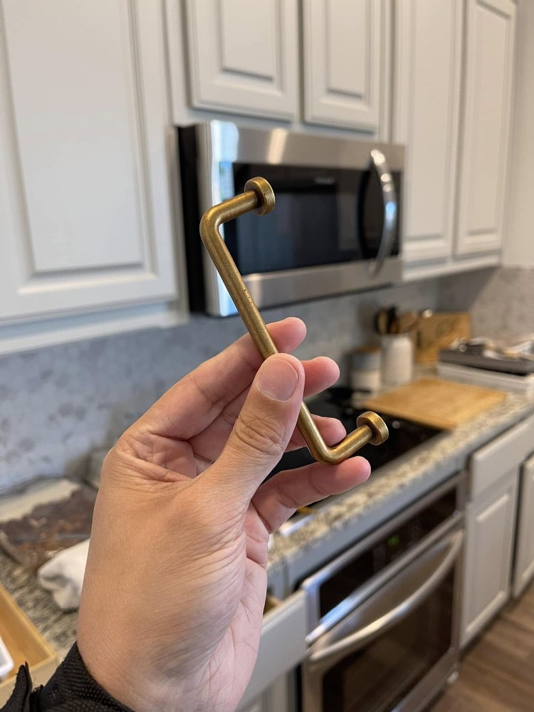 Close-up detail of a new brass cabinet pull ready for installation