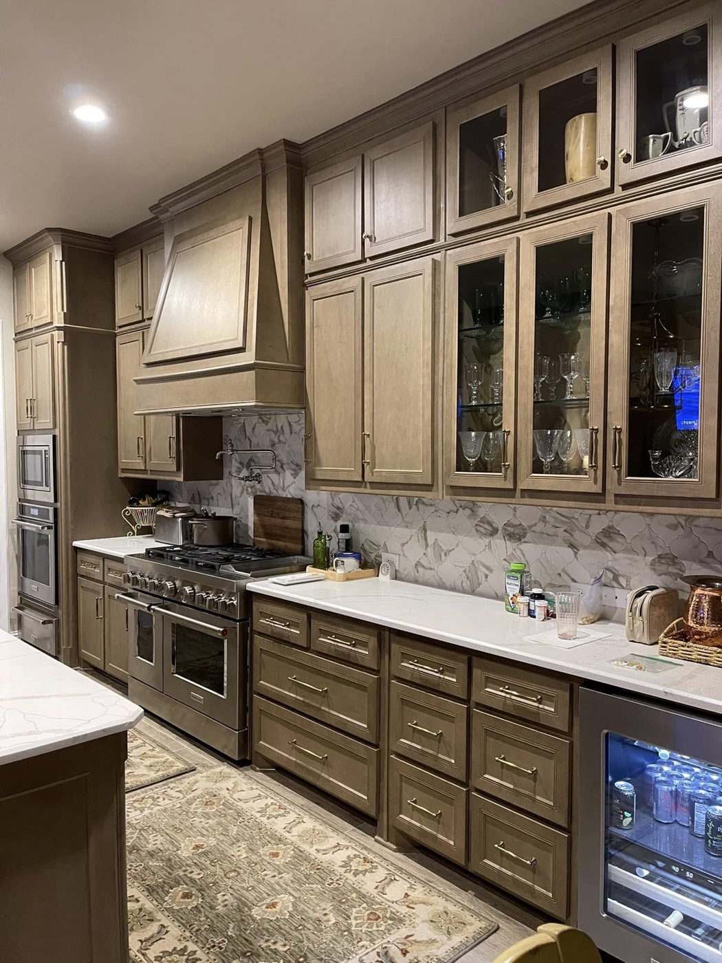 Traditional stained wood kitchen with glass-front cabinets and brass hardware