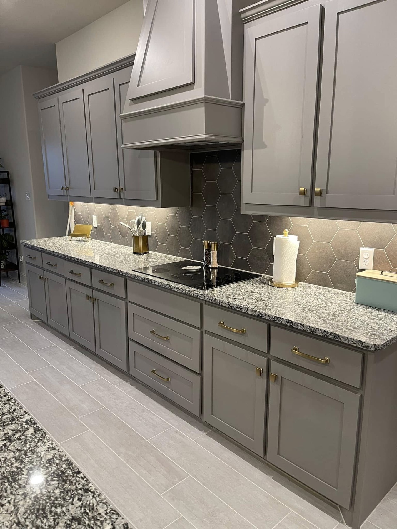 Finished kitchen with new gold cabinet pulls installed on light gray cabinetry